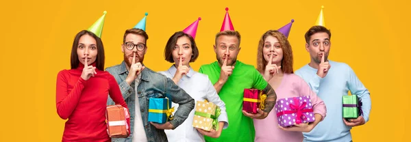 Personnes excitées préparant des cadeaux d'anniversaire et montrant le signe shh — Photo