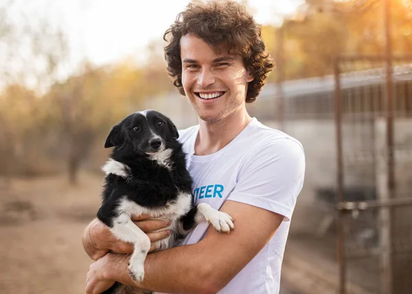 Happy male volunteer hugging dog — Stock Photo, Image