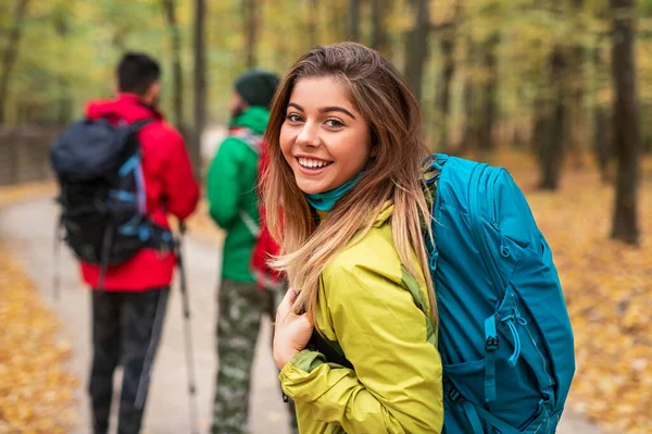Mujer feliz caminando en el bosque de otoño con amigos — Foto de Stock