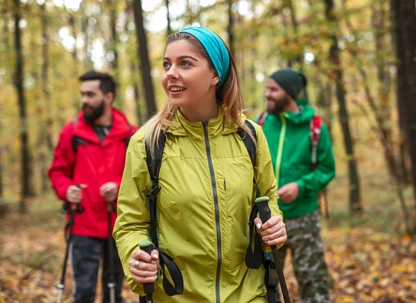 Mujer asombrada caminando en el bosque cerca de amigos — Foto de Stock