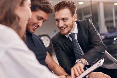 Müşterilere kontrat gösteren dost canlısı bir araba satıcısı