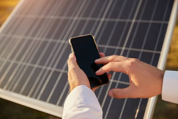 Homem de colheita usando smartphone na fazenda solar — Fotografia de Stock