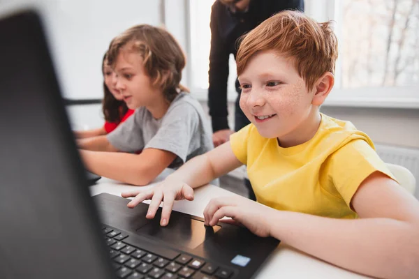 Opgewonden jongen werken met laptop in de klas — Stockfoto