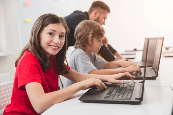 Niños que trabajan con computadoras portátiles durante la clase en la escuela — Foto de Stock