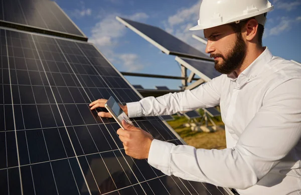 Engenheiro com smartphone trabalhando na central de energia solar — Fotografia de Stock