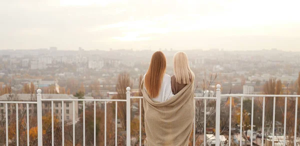 Girlfriends wrapped in scarf enjoying cityscape in cold day — Stock Photo, Image