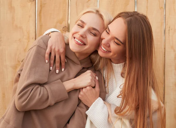 Feliz namoradas em roupas quentes abraçando juntos — Fotografia de Stock