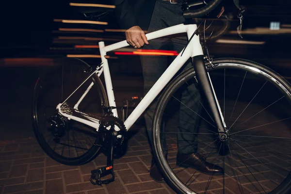Анонимный бизнесмен с велосипедом на темной улице — стоковое фото