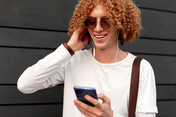 Hombre alegre escuchando música con smartphone y auriculares — Foto de Stock