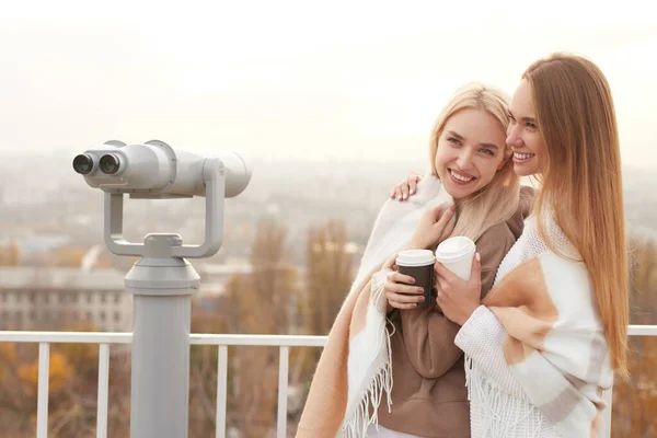 Feliz namoradas com café em pé no deck de observação — Fotografia de Stock