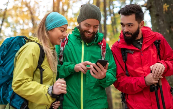 Felices excursionistas usando smartphone en el bosque — Foto de Stock