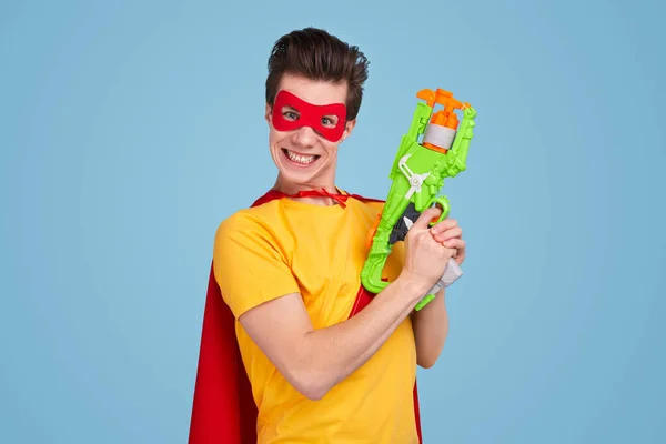 Super-herói engraçado com arma de brinquedo — Fotografia de Stock
