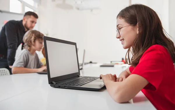 Chica feliz usando el ordenador portátil durante la lección — Foto de Stock