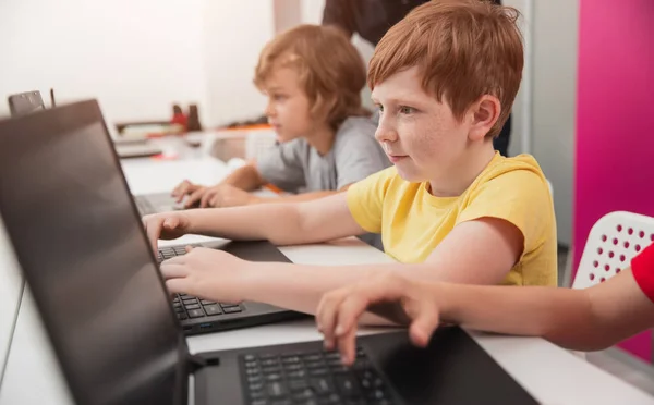 Estudante focado trabalhando no laptop durante a aula da escola — Fotografia de Stock