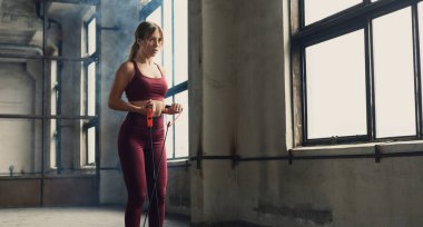 Sporcu kadın direniş bandıyla egzersiz yapıyor.