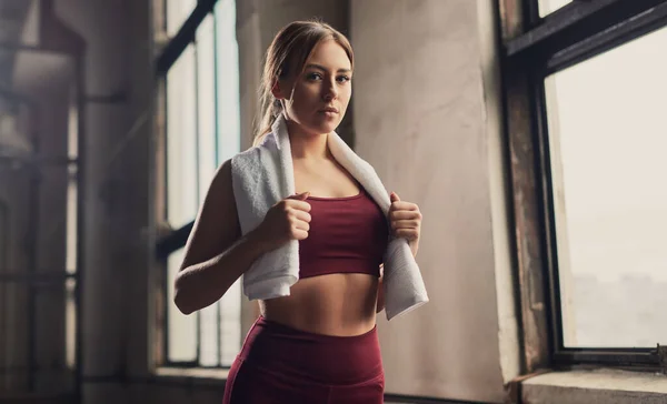 Slim sportswoman during break in gym — Stock Photo, Image