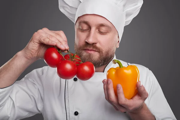 Chef barbudo cheirando legumes frescos — Fotografia de Stock