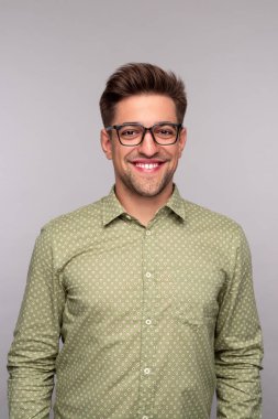 Kameraya gülümseyen akıllı genç adam.