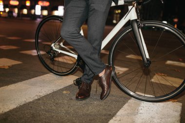 Bisikletli zarif iş adamı yaya geçidinde duruyor.