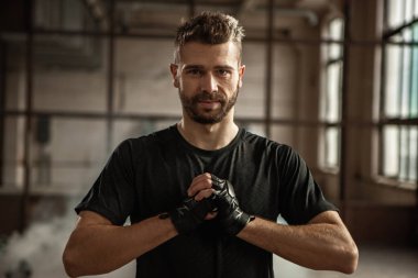 Ciddi sakallı dövüşçü bokstan önce ellerini ısıtıyor.