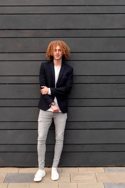 Stylish man with curly hair on city street