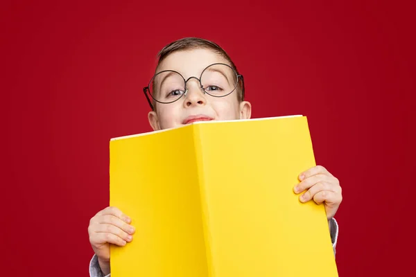 Smart skolpojke med gul bok — Stockfoto