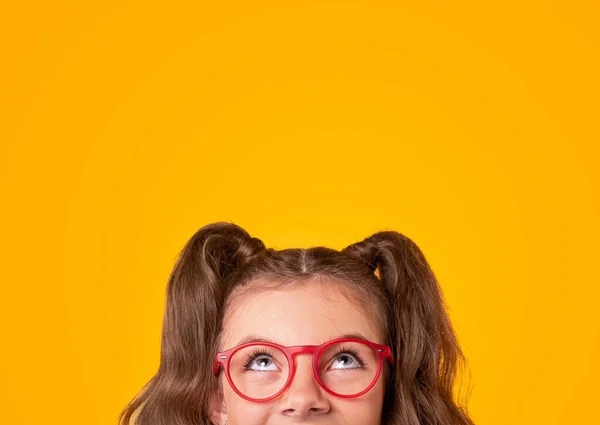 유행하는 안경을 쓴 행복 한 소녀가 올려다보고 있다 — 스톡 사진