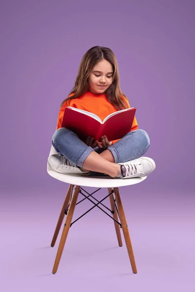 Menina leitura livro na cadeira — Fotografia de Stock