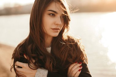 Soğuk bir günde yalnız bir kadın gölün kenarında duruyor.