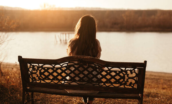 Lonely woman resting near lake