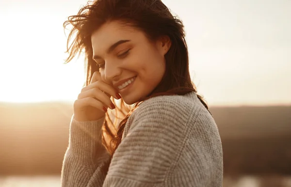 Mulher feliz em suéter desfrutando do pôr do sol na natureza — Fotografia de Stock