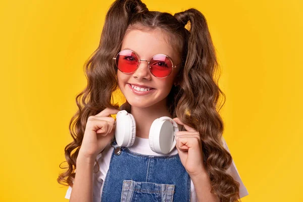Gelukkig meisje in stijlvolle zonnebril met hoofdtelefoon — Stockfoto