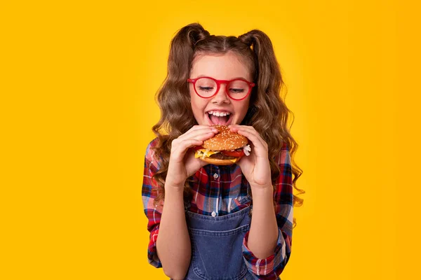 맛있는 햄버거를 먹는 행복 한 소녀 — 스톡 사진