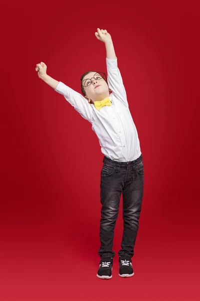 Malý školáček natahuje paže nahoru — Stock fotografie