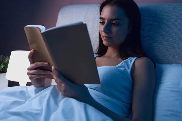 Donna che legge libro a letto — Foto Stock