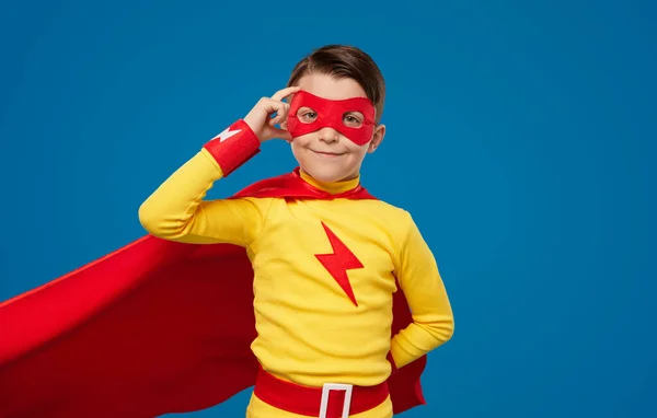 Ragazzo sorridente in costume da supereroe e maschera — Foto Stock