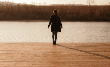 Göl kenarındaki rıhtımda tanınmayan çaresiz bir kadın.