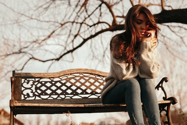 Szomorú nő ül a padon a parkban — Stock Fotó