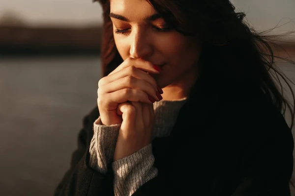 Mujer tierna calentando las manos cerca del lago en otoño —  Fotos de Stock