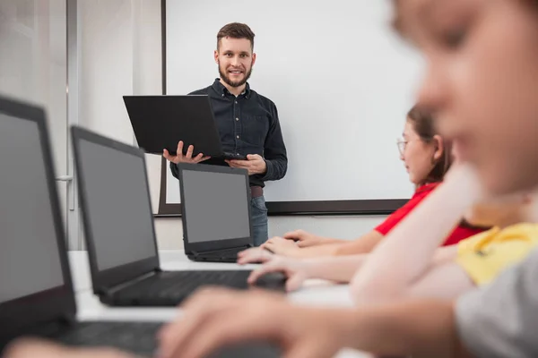 Bedrijf van kinderen die laptops gebruiken tijdens de les — Stockfoto