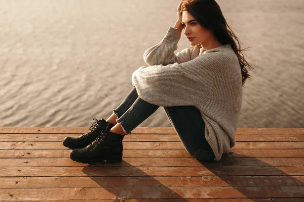 Dreamy woman resting on pier near lake — Stock Photo, Image