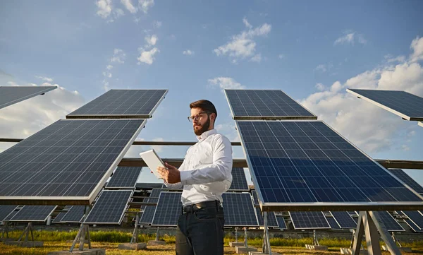 Uomo d'affari che utilizza tablet vicino ai pannelli solari — Foto Stock