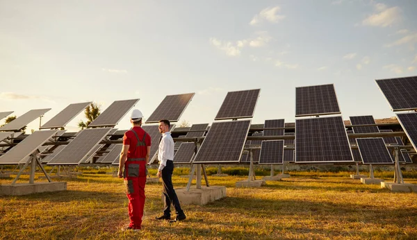Gerente e trabalhador que se comunica na central solar — Fotografia de Stock