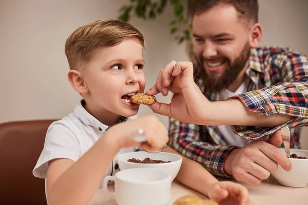 快乐的父亲给儿子吃饼干 — 图库照片