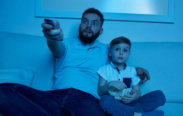 Ojciec i syn oglądają razem film w nocy. — Zdjęcie stockowe