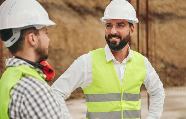 Mutlu inşaatçı iş arkadaşıyla konuşuyor.