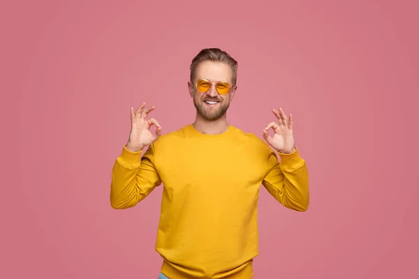 Fröhlicher Mann mit OK-Geste und Blick in die Kamera — Stockfoto