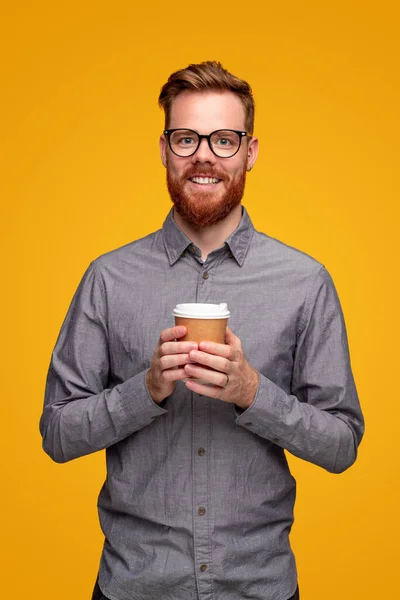 Улыбающийся бородатый мужчина с кофе на вынос — стоковое фото