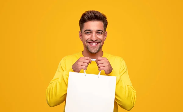 Счастливый человек показывает сумку с покупками — стоковое фото