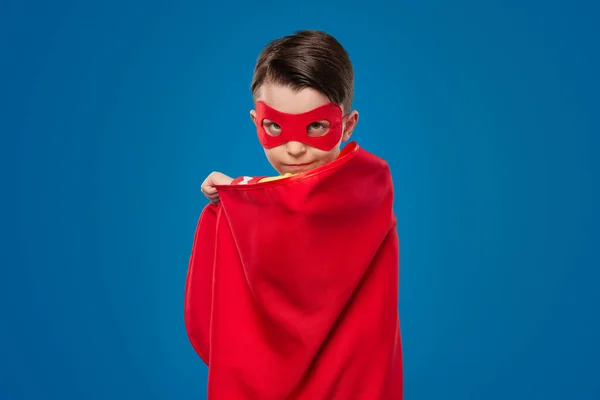 Fiducioso ragazzo supereroe in mantello rosso e maschera — Foto Stock